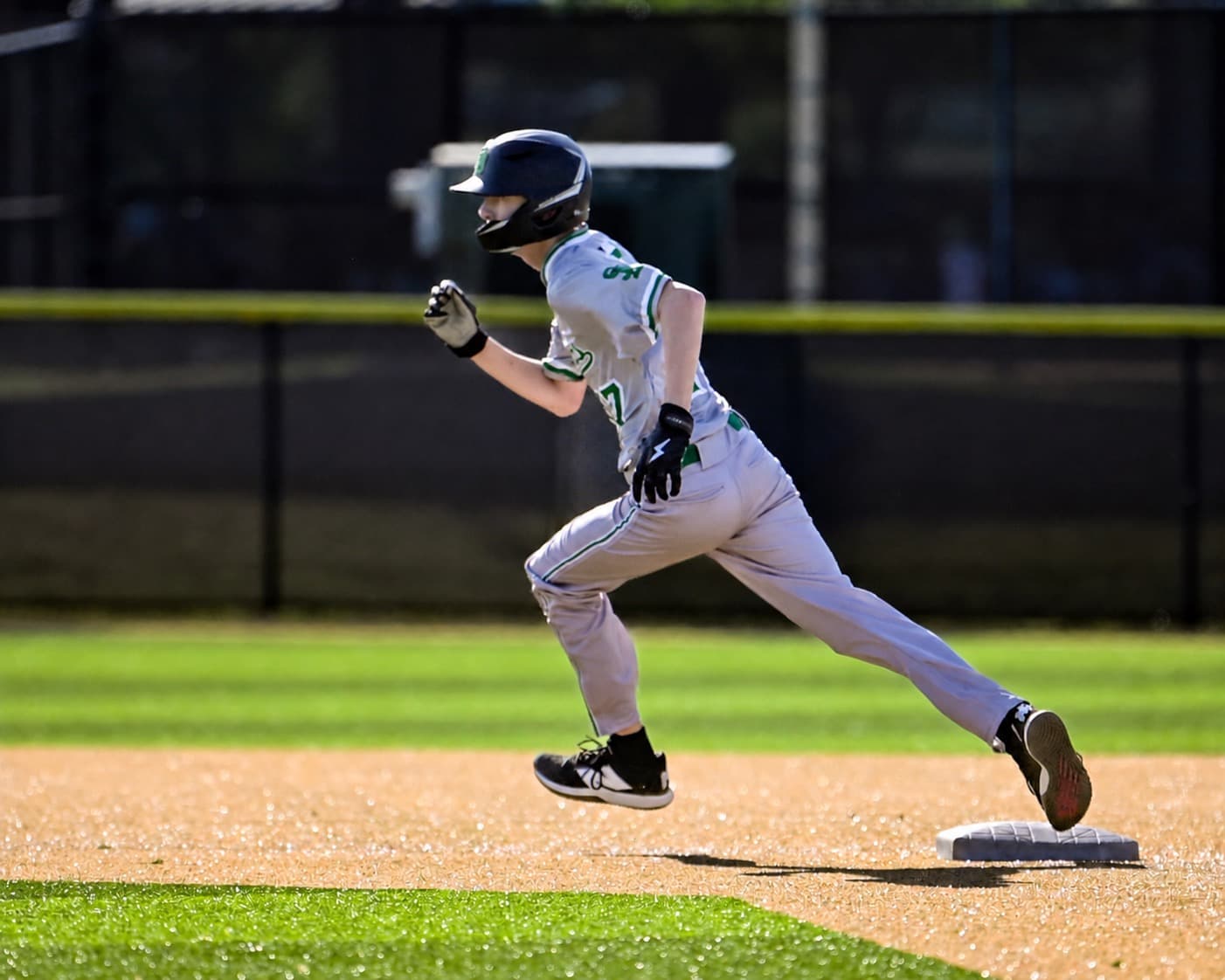 Baseball player running past a base